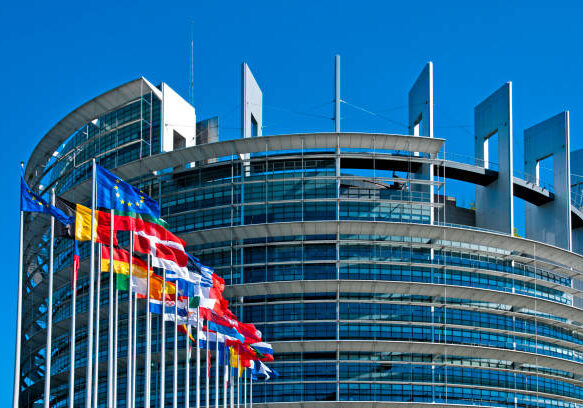 The European Parliament building in Strasbourg, France with flags waving calmly celebrating peace of the Europe. July 12, 2020.